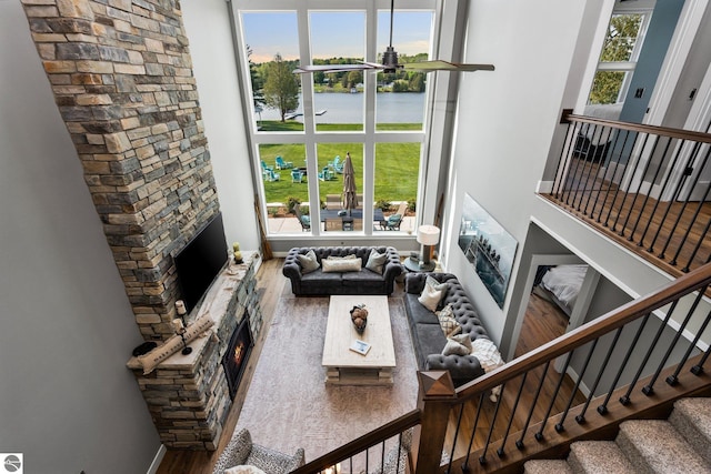 living room featuring hardwood / wood-style floors, a stone fireplace, and a wealth of natural light