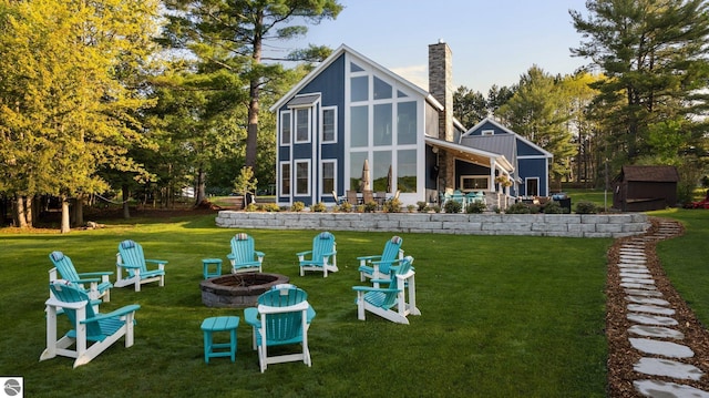 back of house featuring a yard and a fire pit