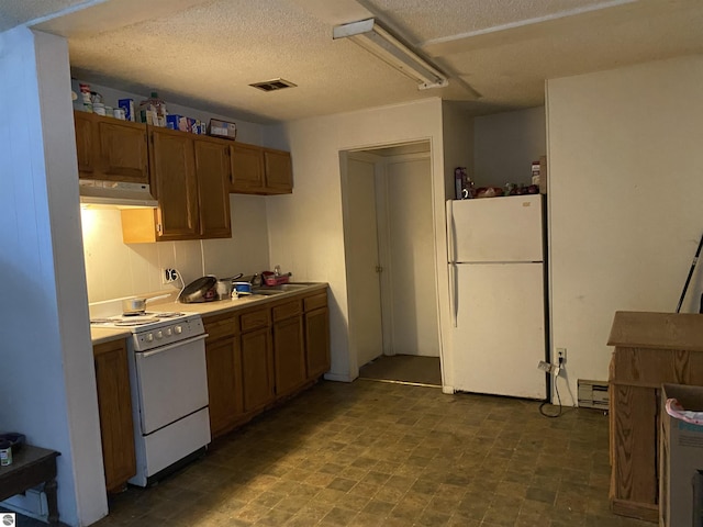 421 N Michigan Ave, Manton, MI 49663 - kitchen with a textured ceiling, a baseboard radiator, and white appliances
