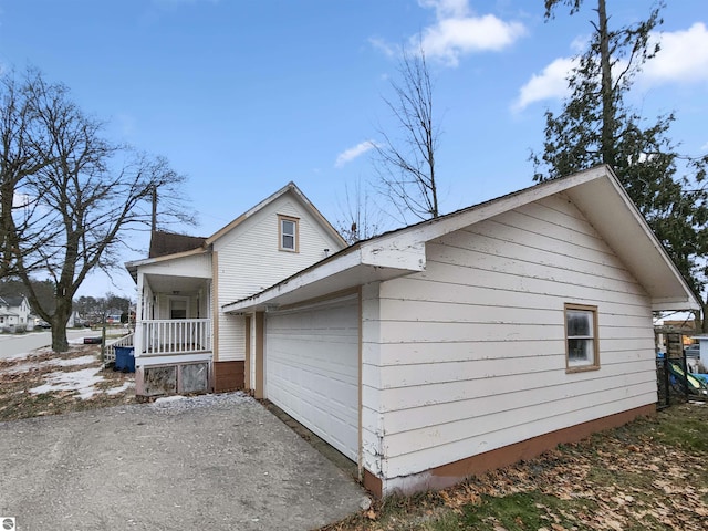 view of home's exterior with a porch and a garage