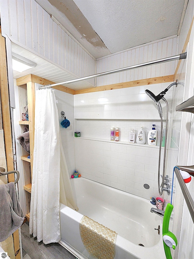 bathroom with hardwood / wood-style floors, a textured ceiling, and shower / tub combo with curtain