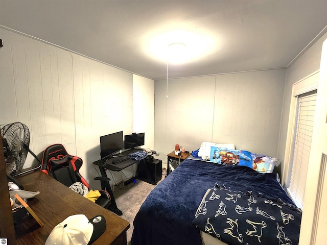 bedroom featuring carpet flooring and wood walls