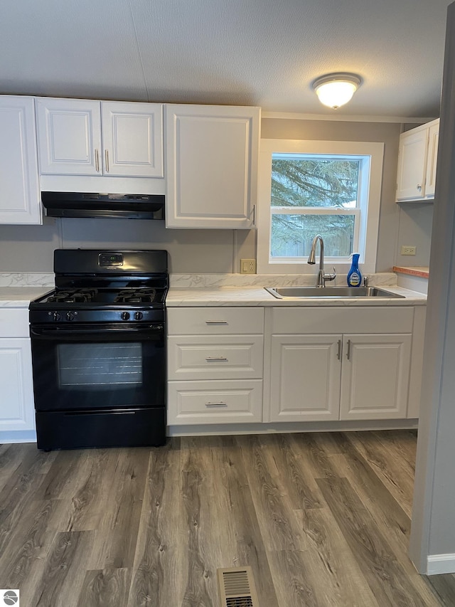 kitchen featuring sink, dark hardwood / wood-style flooring, white cabinetry, black range with gas cooktop, and extractor fan