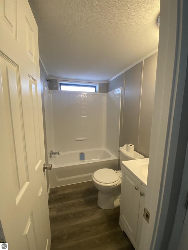 full bathroom with ornamental molding, vanity, bathing tub / shower combination, hardwood / wood-style floors, and toilet