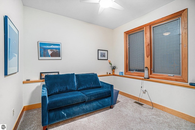 living area featuring carpet floors and ceiling fan