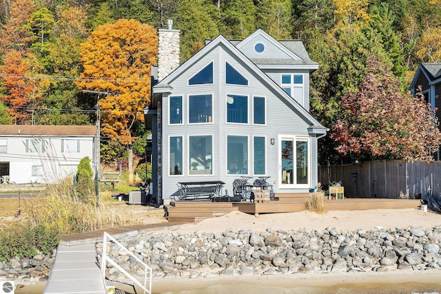 rear view of house with central AC and a deck