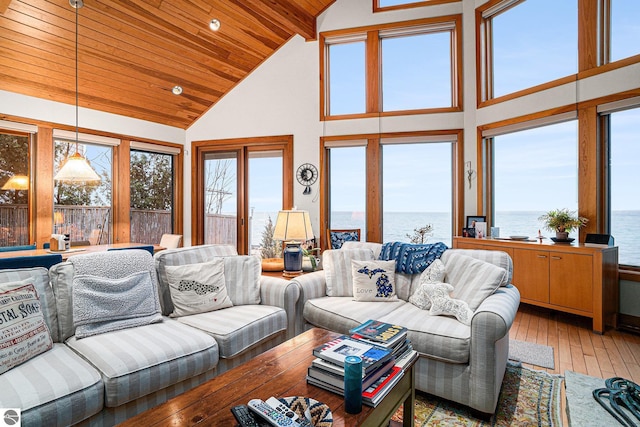 living room with hardwood / wood-style floors, a water view, wood ceiling, and high vaulted ceiling