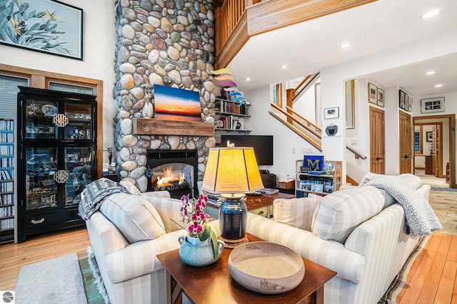 living room with light hardwood / wood-style floors and a stone fireplace