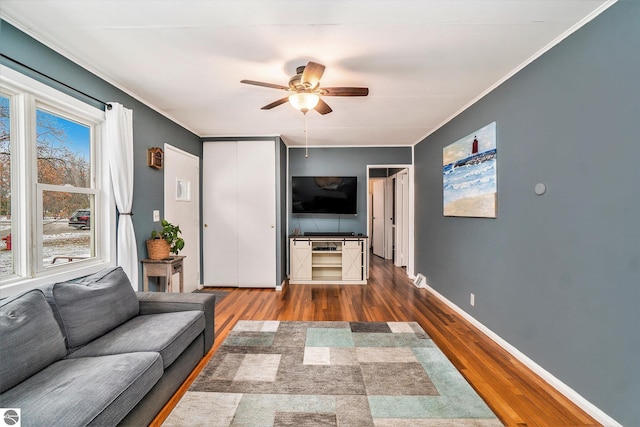 living room with hardwood / wood-style flooring, ceiling fan, and ornamental molding