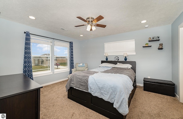 carpeted bedroom featuring a textured ceiling and ceiling fan