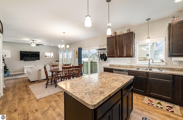 kitchen featuring ceiling fan with notable chandelier, a kitchen island, sink, and light hardwood / wood-style flooring