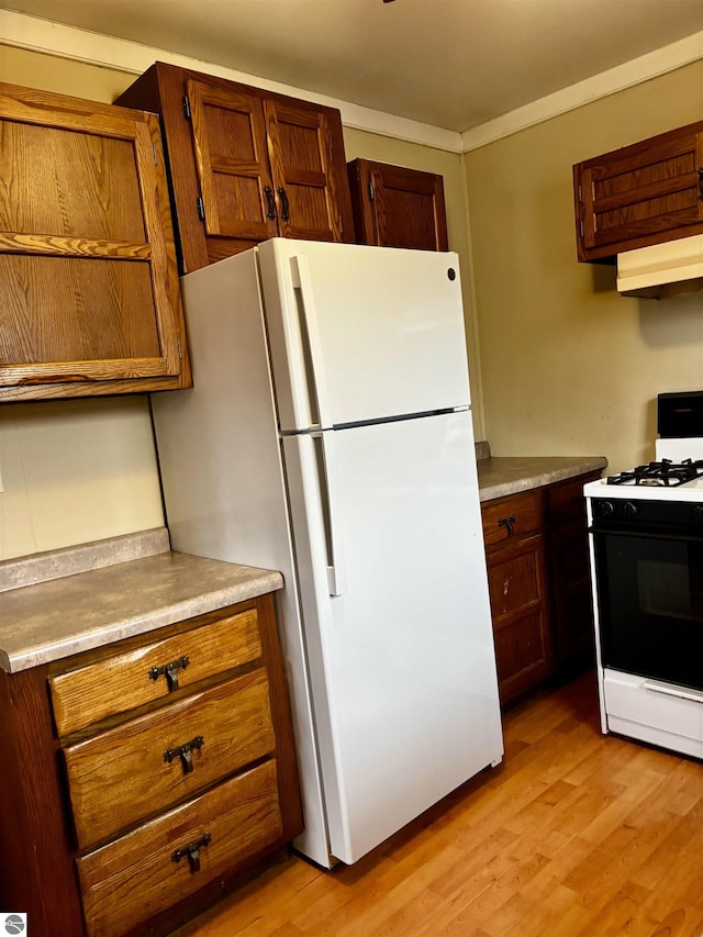 kitchen featuring light wood-type flooring and white appliances