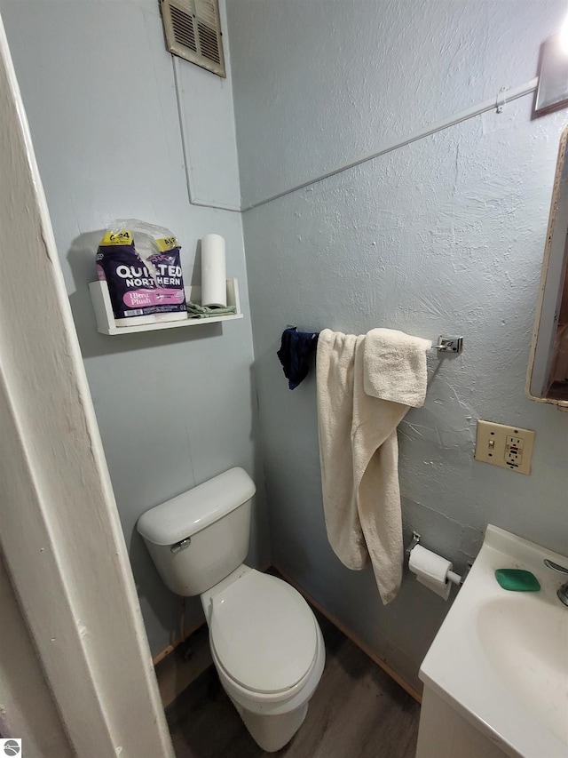 bathroom featuring hardwood / wood-style flooring, vanity, and toilet