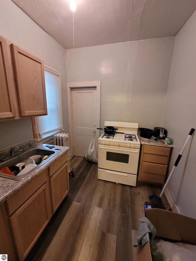 kitchen with light brown cabinets, sink, white gas range oven, and dark wood-type flooring