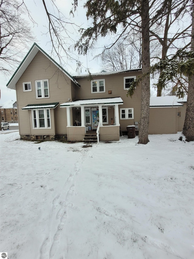 view of snow covered back of property