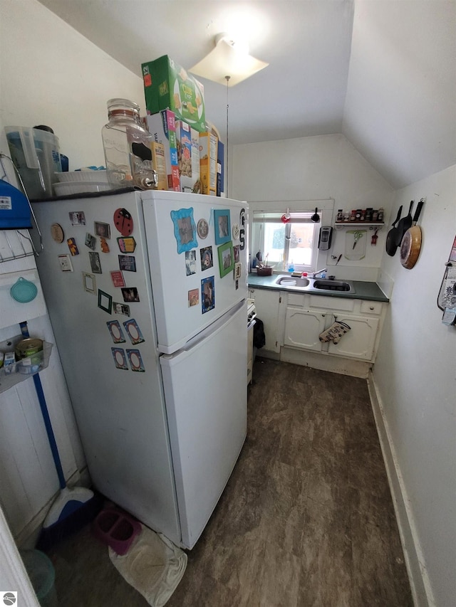 kitchen featuring white cabinets, dark hardwood / wood-style flooring, white refrigerator, and lofted ceiling