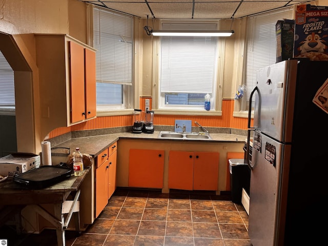 kitchen with stainless steel refrigerator, a paneled ceiling, and sink