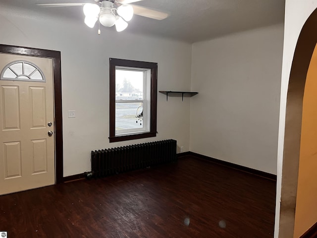 foyer entrance with radiator heating unit, dark hardwood / wood-style floors, and ceiling fan