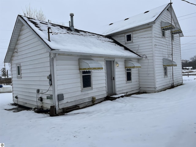 view of snow covered rear of property