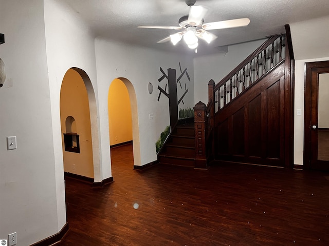 interior space featuring ceiling fan, dark wood-type flooring, and a textured ceiling