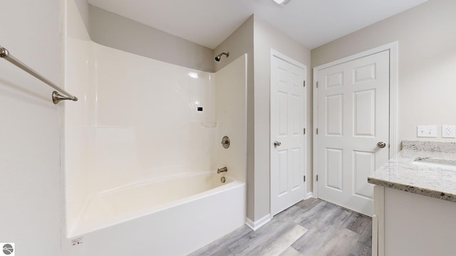 bathroom featuring hardwood / wood-style floors, vanity, and shower / bath combination