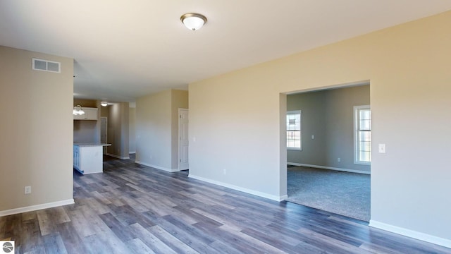 unfurnished room with dark hardwood / wood-style floors and an inviting chandelier