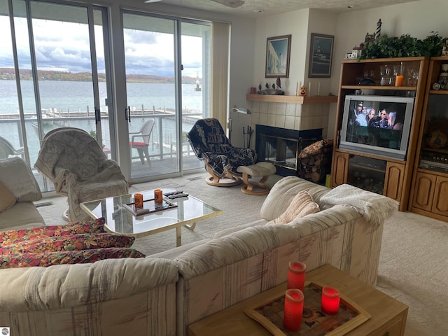 carpeted living room featuring a tiled fireplace