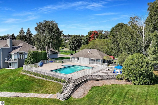 view of pool with a patio and a lawn