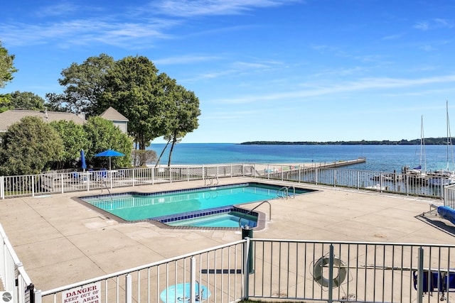 view of pool with a patio area, a community hot tub, and a water view