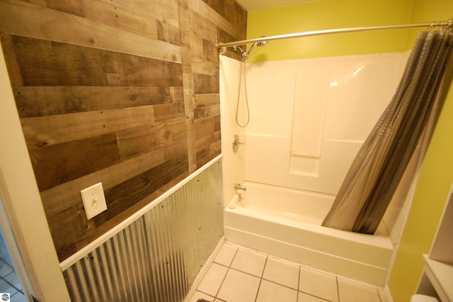 bathroom with tile patterned flooring, shower / bathtub combination with curtain, and wooden walls