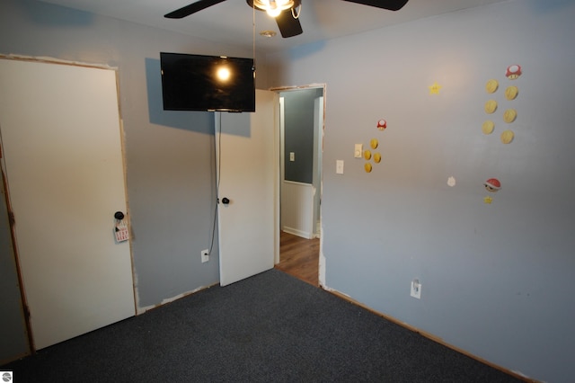 unfurnished bedroom with dark colored carpet and ceiling fan