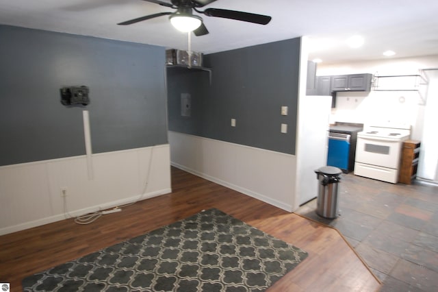 interior space with white range oven, gray cabinets, ceiling fan, and dark wood-type flooring