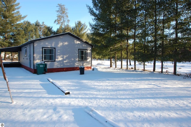 snow covered property featuring a carport