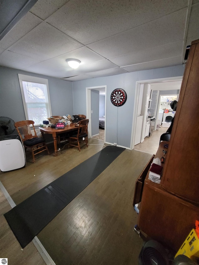 dining space with wood-type flooring and a paneled ceiling