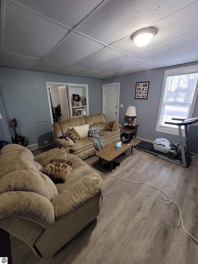 living room with hardwood / wood-style flooring and a drop ceiling