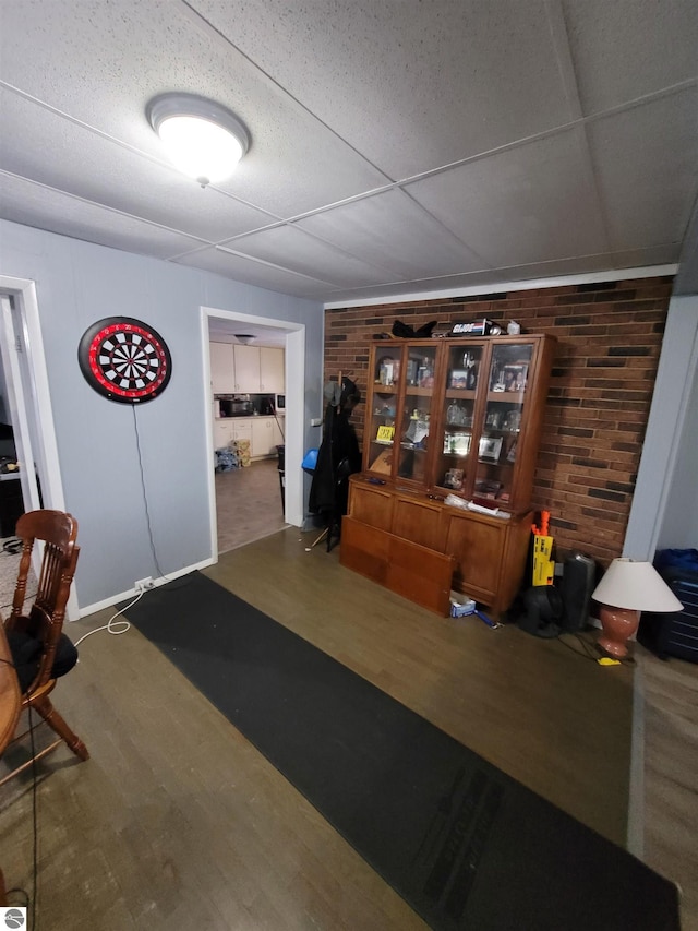 interior space featuring a paneled ceiling and wood-type flooring