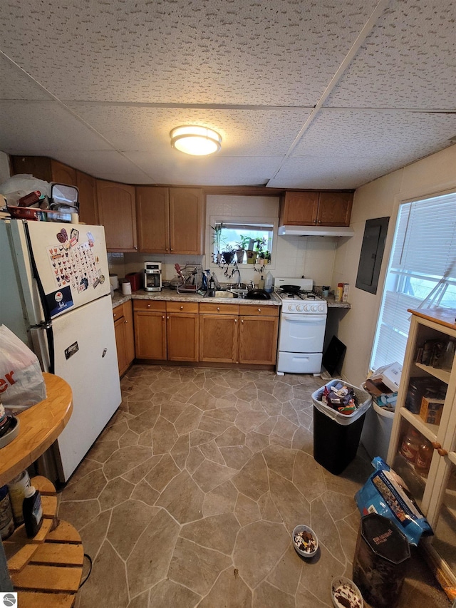 kitchen featuring a paneled ceiling, electric panel, white appliances, and sink