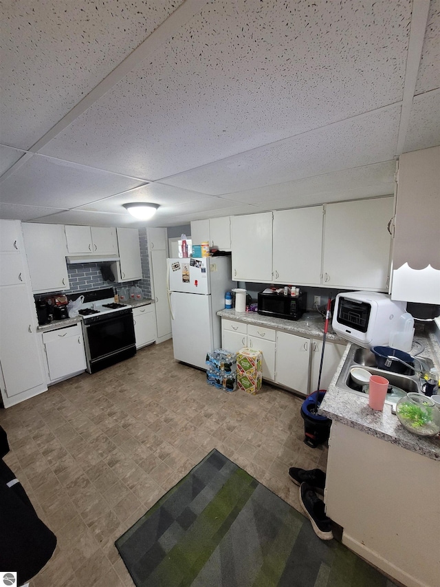 kitchen with black range with electric cooktop, white refrigerator, white cabinetry, and a drop ceiling