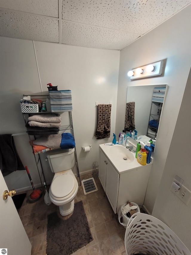 bathroom featuring a paneled ceiling, vanity, and toilet