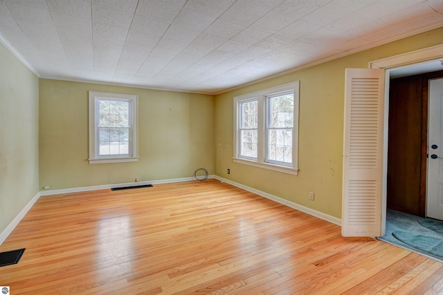 spare room with crown molding and light hardwood / wood-style floors