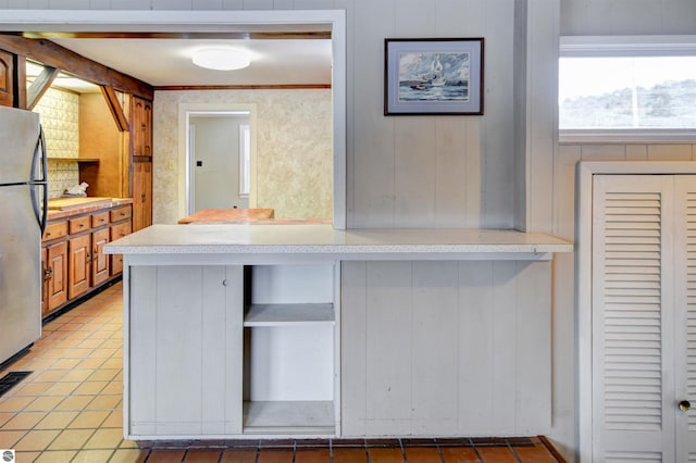 kitchen with tile patterned floors and stainless steel fridge