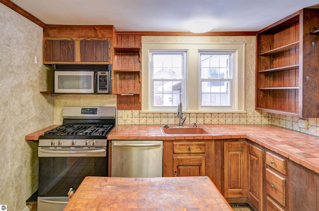 kitchen featuring tile counters, appliances with stainless steel finishes, and sink