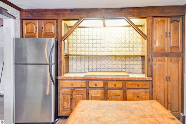 kitchen featuring tile counters and stainless steel refrigerator