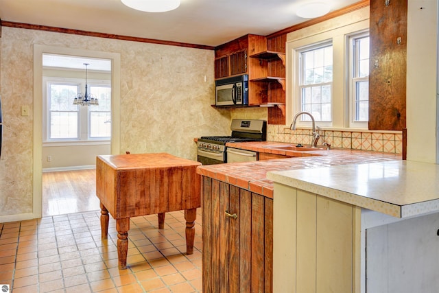 kitchen featuring stainless steel appliances, an inviting chandelier, sink, hanging light fixtures, and crown molding