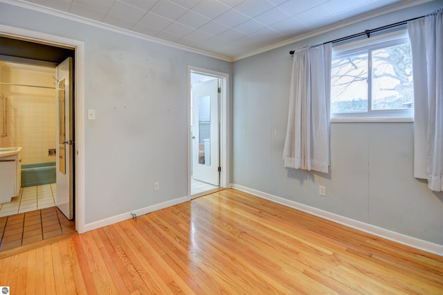 unfurnished room with light wood-type flooring and ornamental molding