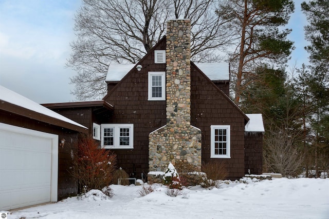 view of snow covered exterior with a garage