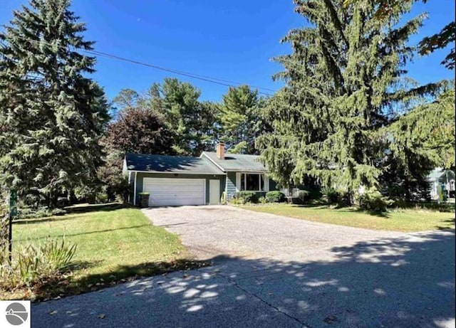 view of front of home with a front yard and a garage