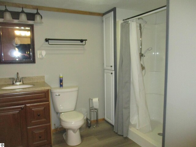 bathroom with a shower with shower curtain, vanity, toilet, and wood-type flooring