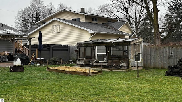 back of property with a yard and a hot tub