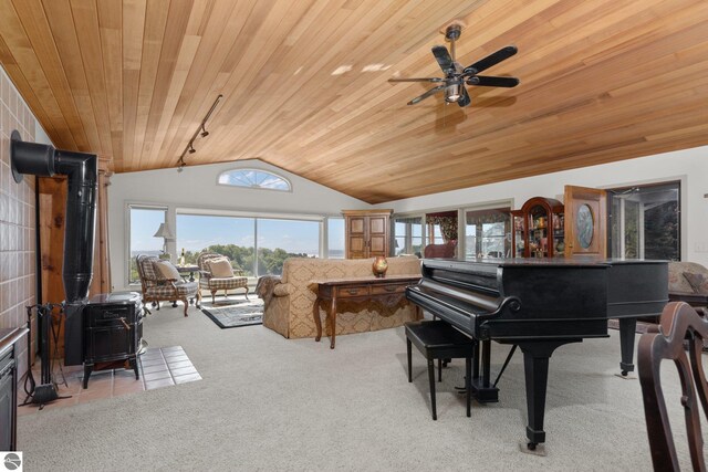 10343 E Hilltop Rd, Suttons Bay, MI 49682 - sitting room featuring lofted ceiling, a wood stove, ceiling fan, light colored carpet, and wood ceiling